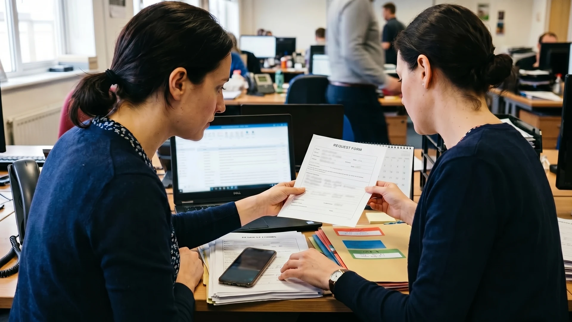 Schreibtisch mit Telefon, Formularen und Posteingang, an dem Anfragen vorqualifiziert werden.